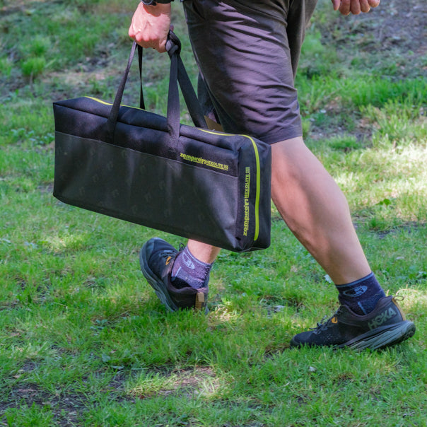 Person carrying a Zempire Hexolite table in a black carrying case