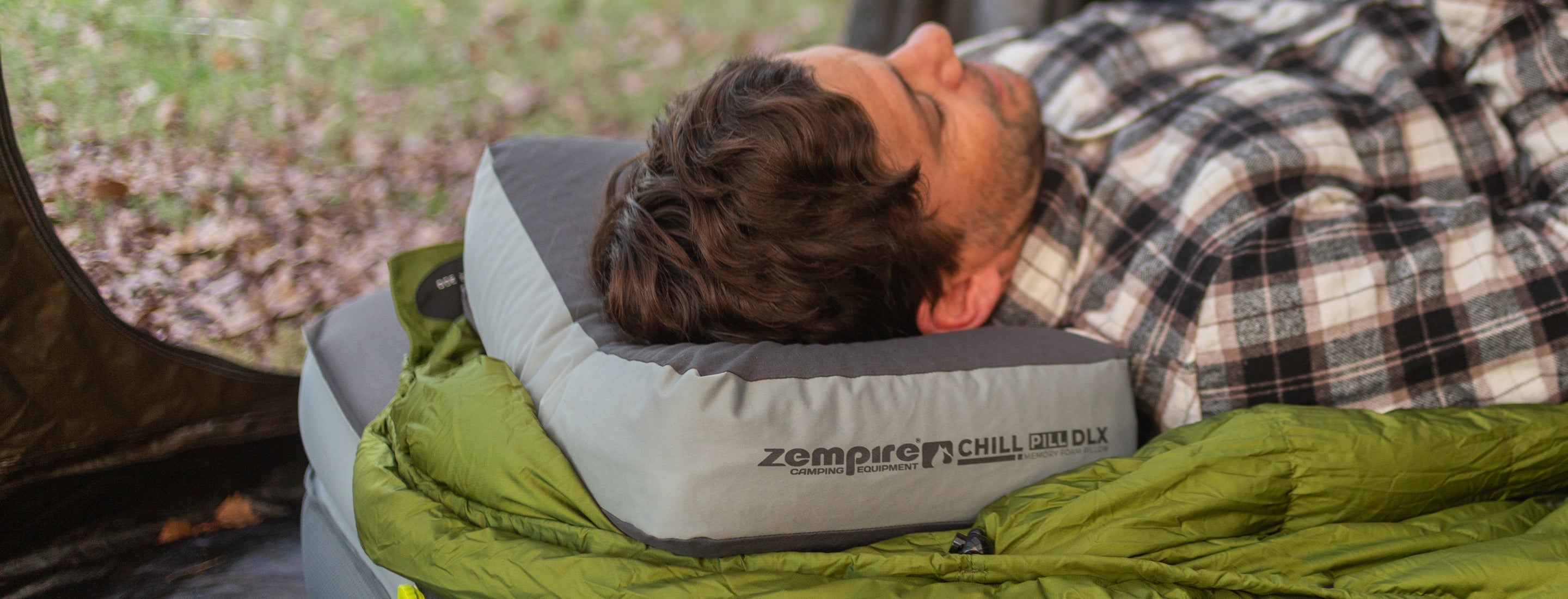 Person lying on a Zempire Chill Pill DLX camping pillow.